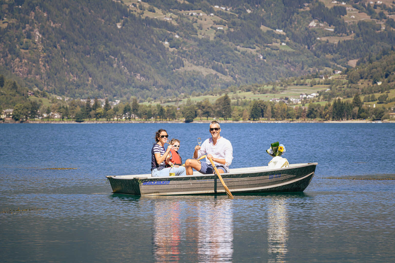 Una famiglia su una barca a remi sul lago di Poschiavo (CH)